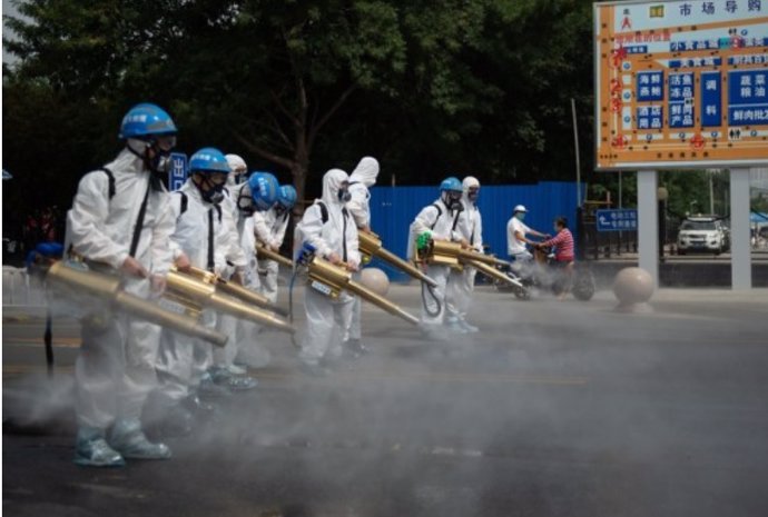 Miembros del equipo del equipo de limpieza de Pekín realizan una desinfección en el mercado mayorista de Yuegezhuang ubicado en la capital china.