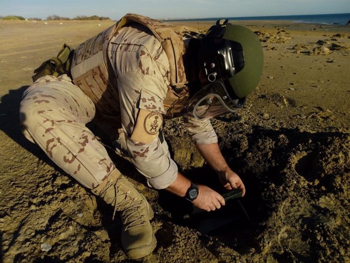 Operador del EDE con la granada de mortero encontrada en la Playa de Camposoto