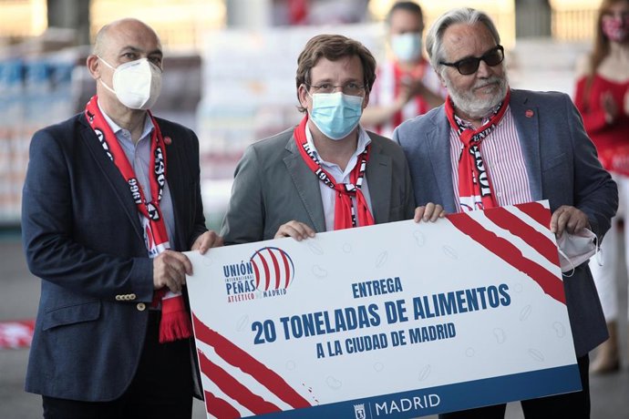 El alcalde de Madrid, José Luis Martínez-Almeida (c), sostiene la donación de 20 toneladas de alimentos para Madrid realizada por el presidente de la Unión Internacional de Peñas del Atlético de Madrid, Eduardo Fernández 