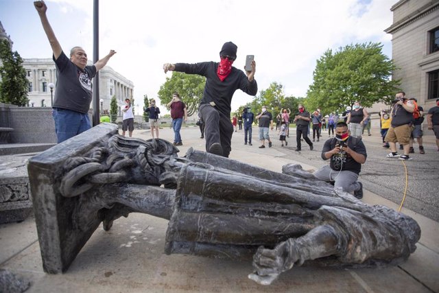 10 June 2020, US, Saint Paul: A man kicks the statue of Christopher Columbus as it lays down on the ground after being pulled down by Native American activists at the Minnesota State Capitol. Photo: Chris Juhn/ZUMA Wire/dpa