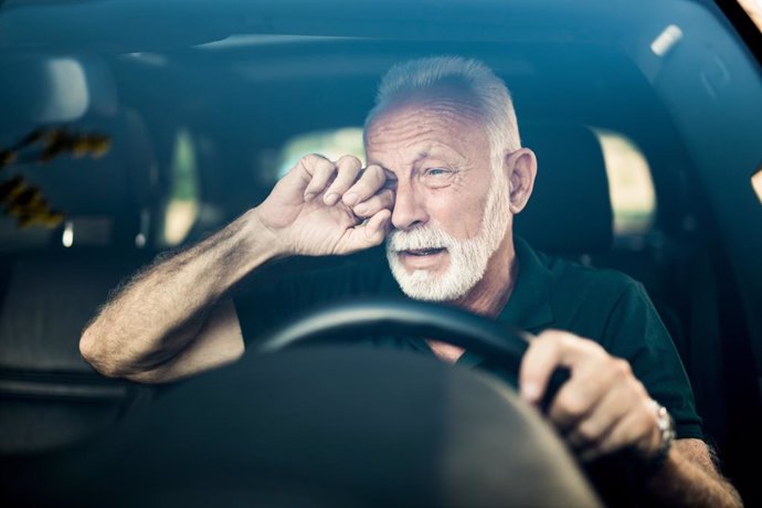 Hombre se frota los ojos mientras conduce.