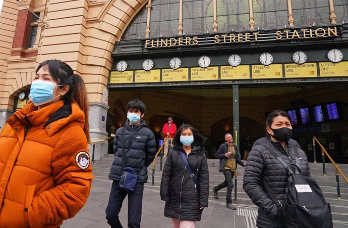 People leave Flinders Street Station while while wearing face masks as a prevent