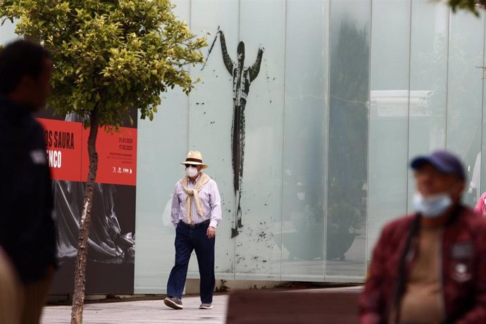 Un hombre camina cerca de la Plaza de Toros en Málaga, donde va protegido por una mascarilla por el virus COVID-19