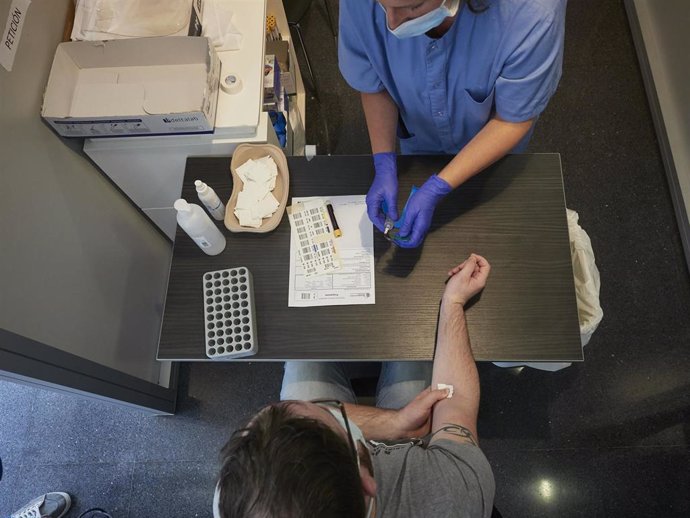 Una trabajadora sanitaria realiza una extracción de muestras para hacer una PCR. 