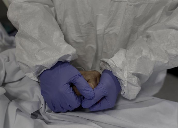 Personal sanitario totalmente protegido atiende a un paciente ingresado en la Unidad de Cuidados Intensivos (Archivo)