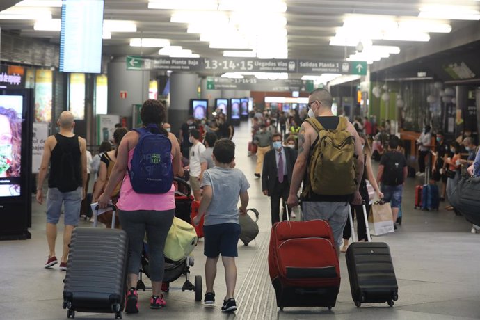 Una multitud de personas con maletas caminan por la estación de Renfe Madrid Puerta de Atocha en el primer día laborable tras el estado de alarma, en Madrid (España), a 22 de junio de 2020.