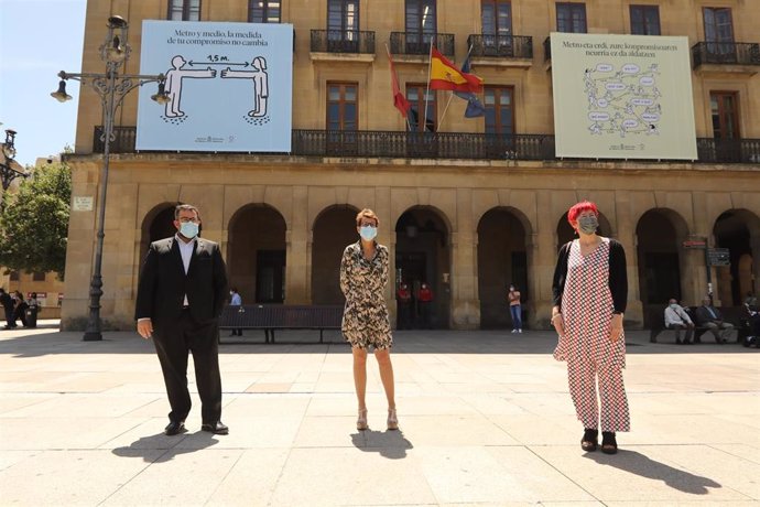 El vicepresidente Javier Remírez, la presidenta María Chivite y la consejera de Salud, Santos Induráin, ante los mensajes de distancia de seguridad colgados en la fachada del Palacio de Navarra