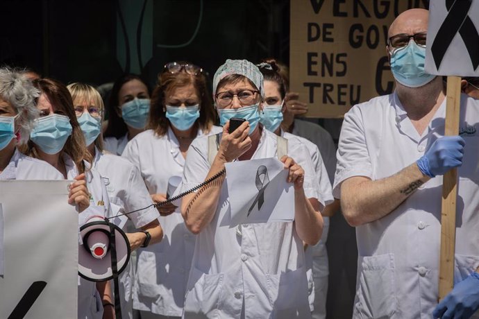 Una trabajadora sanitaria habla por un megáfono junto a otros compañeros de profesión a las puertas del Hospital Clínic de Barcelona. En Barcelona, Catalunya, (España), a 27 de mayo de 2020.