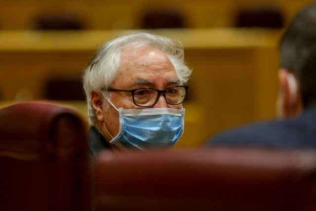 El ministro de Universidades, Manuel Castells, con mascarilla, conversa con un senador poco antes de comparecer en el Senado este martes.