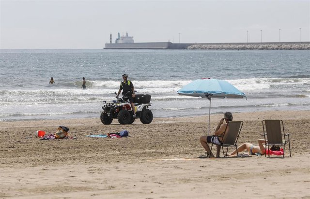 Un agente de la Policía Local de Valencia vigila desde un quad la Playa de la Malvarrosa.