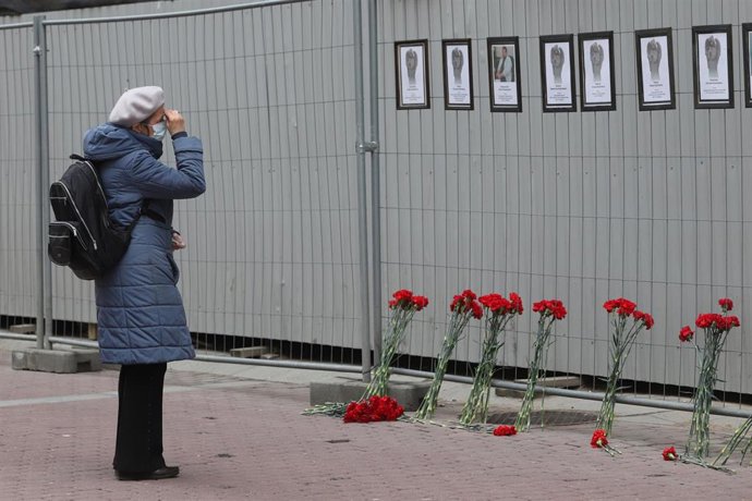 Una mujer ante un muro en el que se rinde homenaje a los trabajadores sanitarios fallecidos por el coronavirus en San Petersburgo