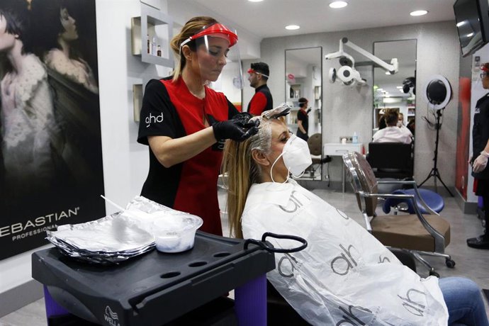 Una peluquera tiñe el pelo a una clienta durante el estado de alarma. 04 de mayo de 2020.