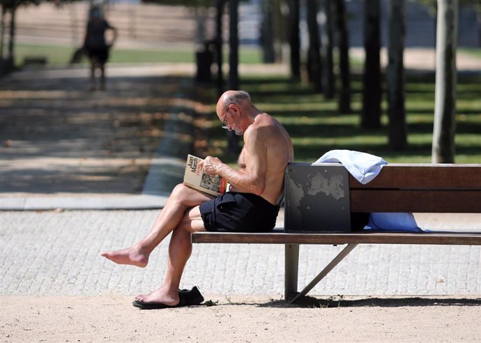 Un hombre lee un libro en un parque parque de Madrid después de que la Agencia Estatal de Meteorología (Aemet) activara ayer lunes la primera alerta amarilla por calor de este año en la Comunidad de Madrid, y cuando hoy está previsto que se alcancen los