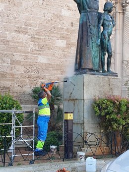 Un operario de Emaya limpia la pintada de la estatua de Juníper Serra en Palma.