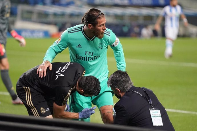 Los médicos atienden a Sergio Ramos de su golpe en la rodilla en el Reale Arena de San Sebastián