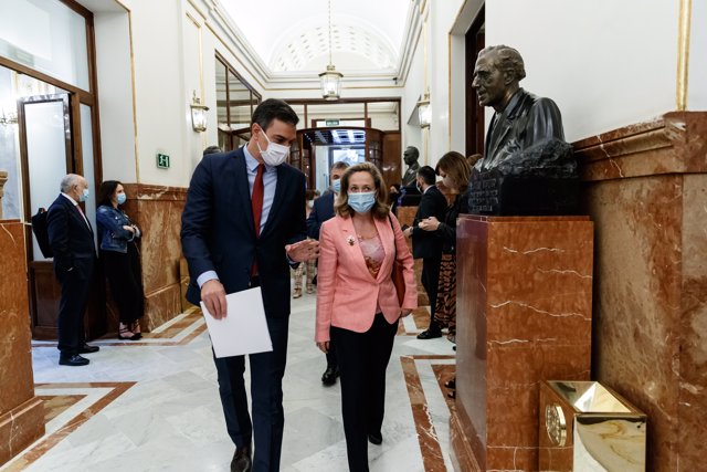 El presidente del Gobierno, Pedro Sánchez (i) y la ministra de Economía y vicepresidenta tercera del Gobierno, Nadia Calviño (d), llegan al Parlamento para intervenir en la sesión de Control al Gobierno