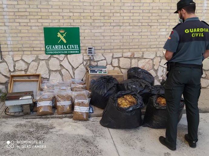 Un agente de la Guardia Civil junto al tabaco aprehendido