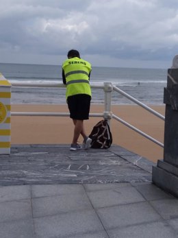 Un 'acomodador de playa' en San Lorenzo, en el primer día de este servicio de control y asesoramiento de aforos