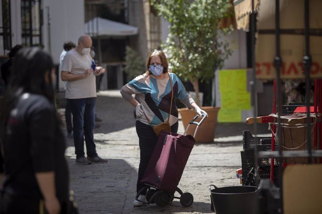 Una mujer protegida con mascarilla y guantes espera su turno en el Mercado de la Feria, un día después de que el Gobierno de España anunciara las medidas de desescalada por la pandemia del coronavirus, (Covid-19). En Sevilla, a 29 de abril de 2020.