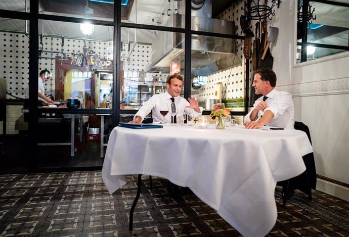 dpatop - 23 June 2020, Netherlands, The Hague: French PresidentEmmanuel Macron (L) and Dutch Prime Minister Mark Rutte sit at a table in the Cru restaurant in Scheveningen. Photo: -/ANP/dpa