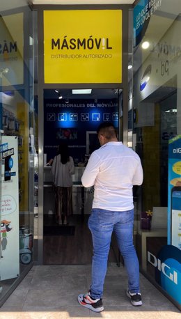 Un hombre espera frente a una tienda de la compañía de telecomunicaciones MásMóvil en Madrid