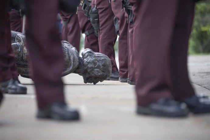 10 June 2020, US, Saint Paul: Christopher Columbus statue is surrounded by state troopers as they guard the statue after being pulled down by Native American activists at the Minnesota State Capitol. Photo: Chris Juhn/ZUMA Wire/dpa