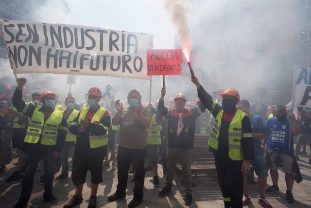 Manifestantes sostienen bengalas como signo de protesta durante una concentración convocada por el comité de Alcoa San Cibrao, frente a la Subdelegación del Gobierno en Lugo, Galicia (España), a 25 de junio