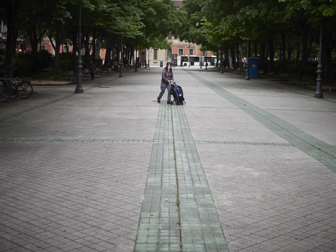 Una mujer lleva un carrito de la compra en el paseo de Sarasate de Pamplona durante el estado de alarma por el coronavirus.