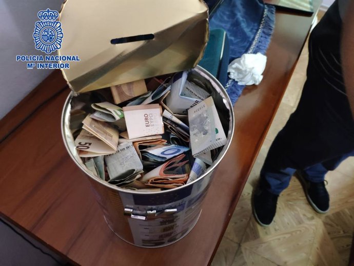 Cubo hucha con dinero incautado en el piso de unos traficantes de droga