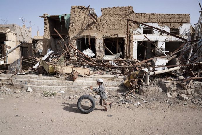 Un niño yemení delante de un edificio destruido. 