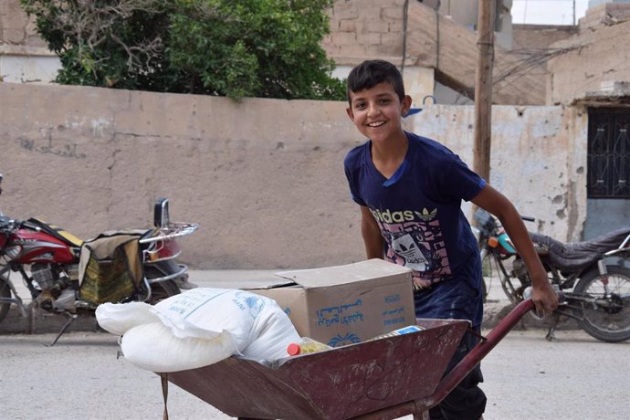Un niño con ayuda alimentaria entregada por el PMA en Siria