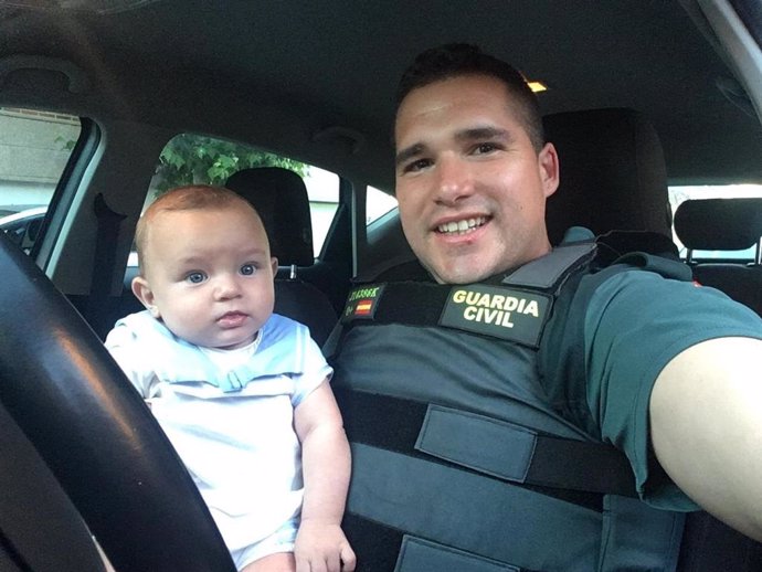 Imagen del guardia civil junto con el bebé al que salvó la vida tras reanimarle cuando había entrado en parada.