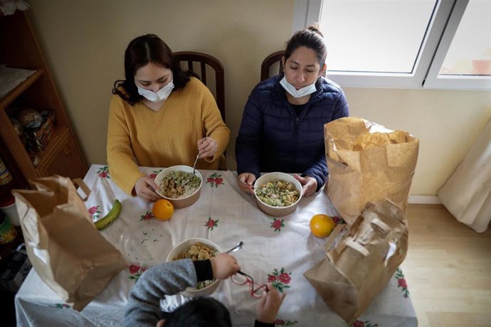 Dos mujeres y un niño durante la comida en su casa del barrio madrileño de Carabanchel 