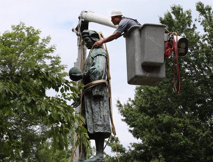 24 June 2020, US, New Haven: A workman for a company contracted by the City of New Haven, secures a statue of Christopher Columbus before it is lifted by a crane and removed from Wooster Square Park. Photo: Stan Godlewski/ZUMA Wire/dpa
