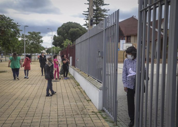 Personas en la puerta de la Fundación Don Bosco, para recibir alimentos del Proyecto Fraternitas, que atiende a familias vulnerables de dos de los barrios más pobres de España, el Polígono Sur y Tres Mil Viviendas de Sevilla.