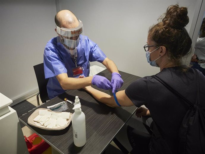 Un trabajador sanitario realiza una extracción de muestras en el recinto ferial REFENA de Pamplona para un programa  cribado y detección de anticuerpos.