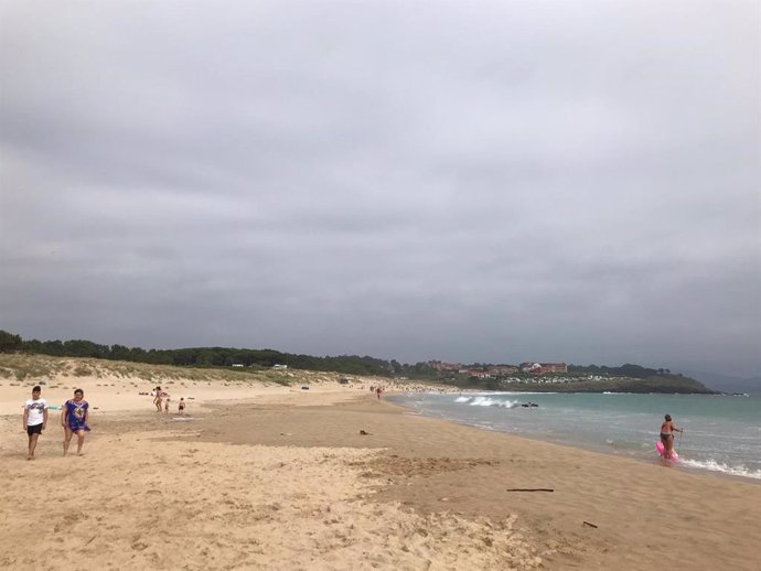 Personas en la playa en un día nublado.