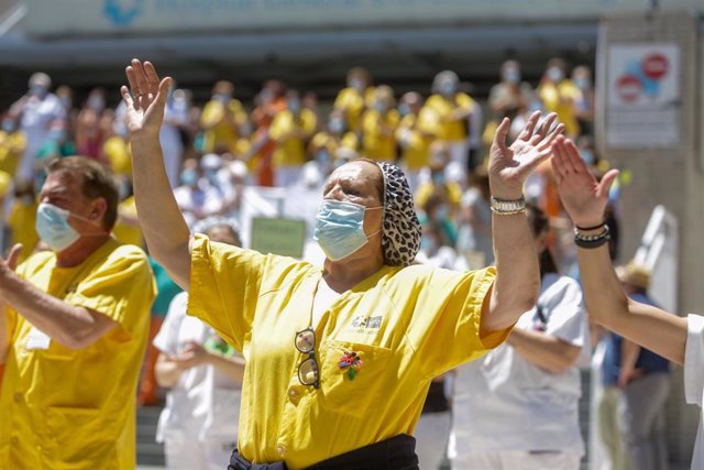 Una mujer levanta las manos durante la concentración convocada por las trabajadoras del servicio de limpieza del Hospital Gregorio Marañón de Madrid en protesta por la privatización de su servicio, en Madrid (España), a 22 de junio de 2020.