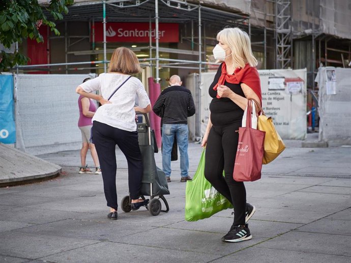 Varias personas esperan en una cola respetando la distancia de seguridad para entrar a una Oficina del Banco Santander durante el segundo día de la fase 0 de la desescalada en la que se permite la apertura con limitaciones de algunos establecimientos, e