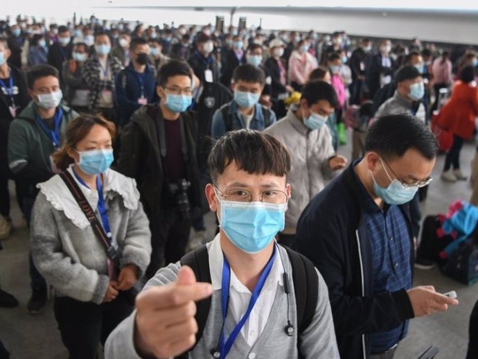 Migrantes con mascarilla en Hubei, China