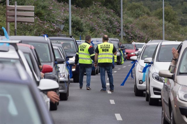 Dos trabajadores de Alcoa caminan entre los coches durante una marcha de coches en caravana convocada por el comité de Alcoa San Cibrao que ha partido desde diferentes puntos de la comarca de A Mariña hasta Lugo, el 28 de junio de 2020