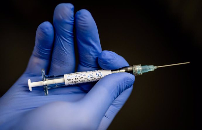 An employee of the German biopharmaceutical company CureVac, holds a syringe with which the first test person was injected with a possible coronavirus vaccine, at the Institute of Tropical Medicine in the University Hospital of Tuebingen. 