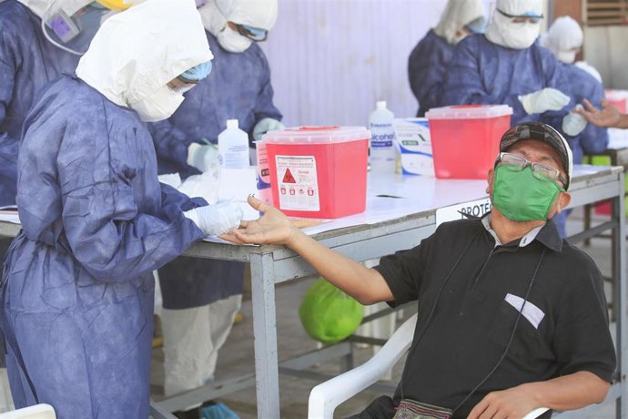 Personal médico somete a la prueba de la COVID-19 a un miembro de la comunidad indígena de Shipibo-Konibo, en Cantagallo, un asentamineto urbano de la capital peruana.