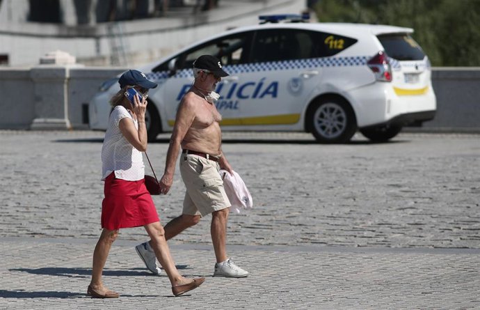 Una pareja camina en Madrid después de que a Agencia Estatal de Meteorología (Aemet) activara ayer lunes la primera alerta amarilla por calor de este año en la Comunidad de Madrid, y cuando hoy está previsto que se alcanzarán los 37 grados en la capital