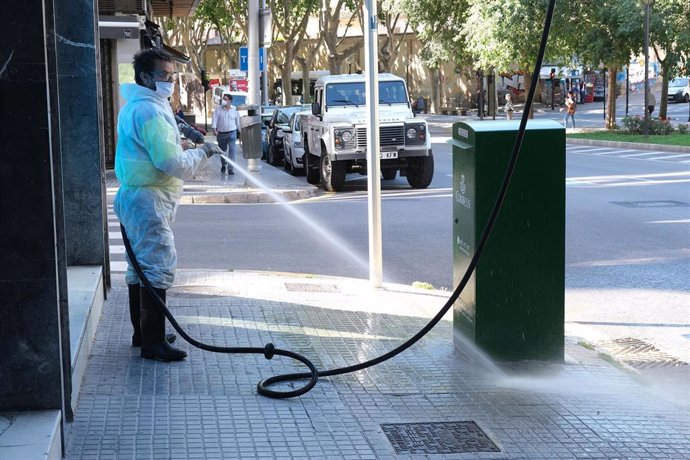 Un operario de limpieza desinfecta un buzón de correos en Palma.