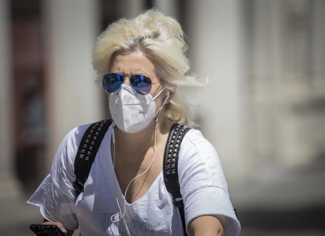 Una mujer con mascarilla y gafas de sol  durante el quinto día de la fase 2 en Sevilla (Andalucía, España), a 29 de mayo de 2020.
