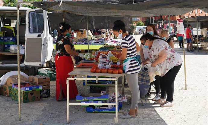 Clientes y vendedores en los puestos del  mercadillo de 'Cerro Amate'  