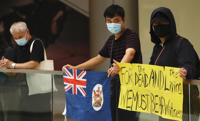 Manifestantes hongkoneses con una bandera de la época colonial.