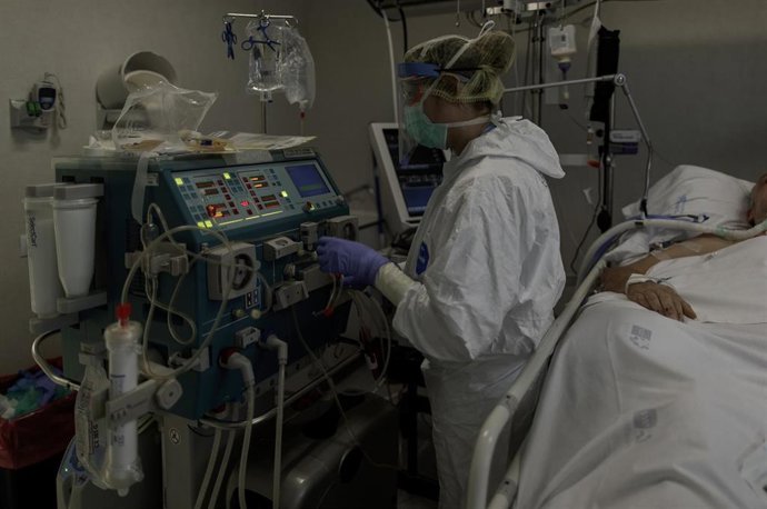 Personal sanitario totalmente protegido atiende a un paciente ingresado en la Unidad de Cuidados Intensivos (Archivo)