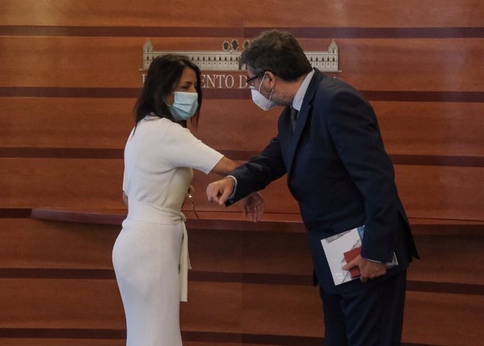 El presidente de la Cámara de Cuentas de Andalucía, Antonio López, saluda con el codo a la presidenta del Parlamento andaluz, Marta Bosquet, al entregarle el informe de la Cuenta General de 2018.